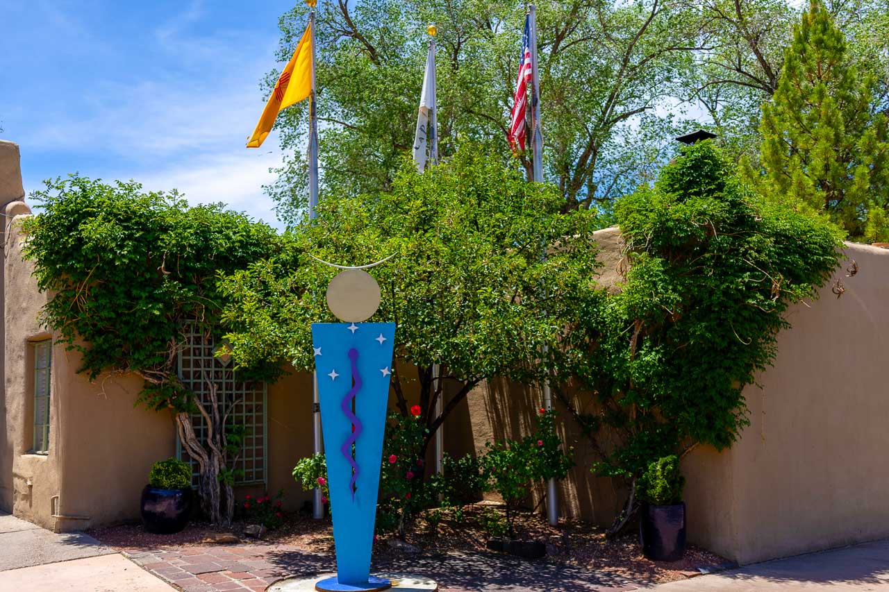 Historic eastside santa fe 3 Historic eastside santa fe adobe courtyard with a sculpture featuring a blue caduceus symbol